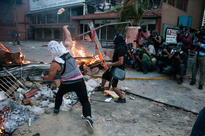 Dans un quartier huppé de Caracas, une mise en scène destinée à l'opinion publique internationale. L'image de ces jeunes "guarimberos" d'extrême droite, alliée à l'occultation des marches pacifiques d'une majorité de vénézuéliens défendant de leur choix électoral, a produit une inversion du réel sur les petits écrans occidentaux.