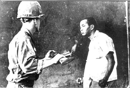 Photo prise par Juan Pérez Terrero lors de l’invasion de la République Dominicaine par 42.000 marines en 1965. L'étudiant Jacobo Ricón résiste au soldat états-unien qui lui ordonne de ramasser des ordures.